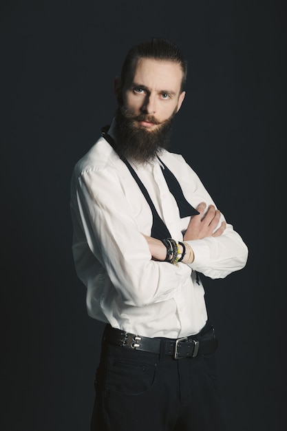 Camisa blanca de hombre con barba estilo hipster en estudio sobre fondo negro