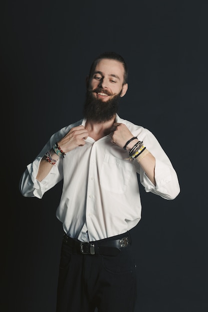 Camisa blanca de hombre con barba estilo hipster en estudio sobre fondo negro