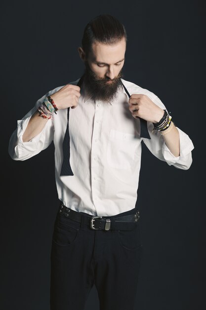 Camisa blanca de hombre con barba estilo hipster en estudio sobre fondo negro