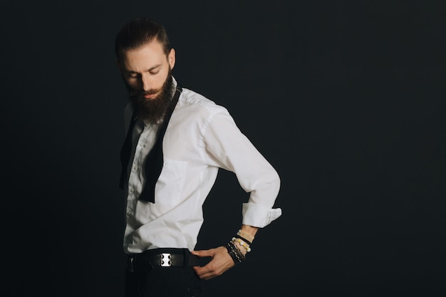 Camisa blanca de hombre con barba estilo hipster en estudio sobre fondo negro