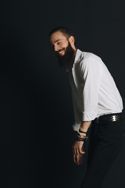 Camisa blanca de hombre con barba estilo hipster en estudio sobre fondo negro