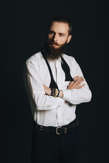Camisa blanca de hombre con barba estilo hipster en estudio sobre fondo negro