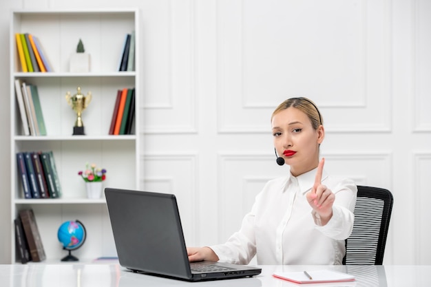 Camisa de oficina de linda chica rubia de servicio al cliente con auriculares y computadora que muestra gesto de parada