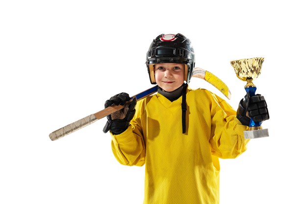 Campeón. Pequeño jugador de hockey con el palo en la cancha de hielo y la pared blanca del estudio