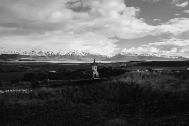 Un campo con una iglesia en la distancia con hermoso cielo nublado