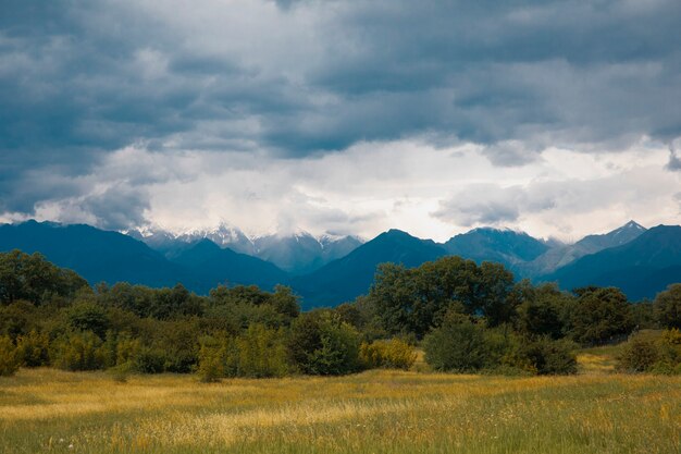 Campos a través de montañas bajo el clima nublado