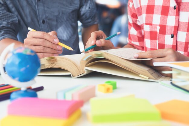 El campus de los estudiantes jóvenes ayuda al amigo a ponerse al día y aprender.