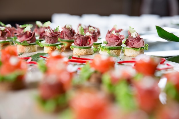 Foto gratuita canapés con carne y pepino en la tabla buffet