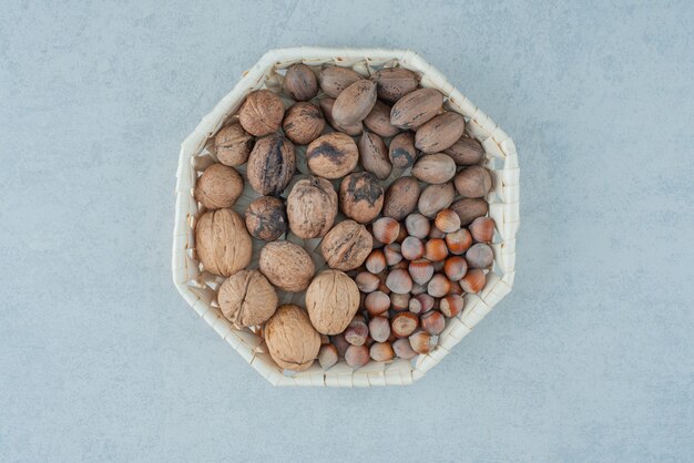 Una canasta con frutos secos saludables sobre fondo de mármol. Foto de alta calidad