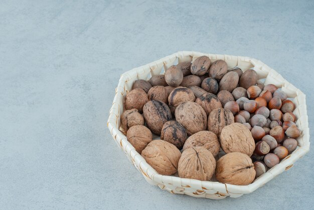 Una canasta con frutos secos saludables sobre fondo de mármol. Foto de alta calidad