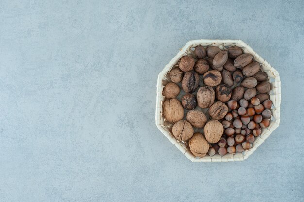 Una canasta con frutos secos saludables sobre fondo de mármol. Foto de alta calidad