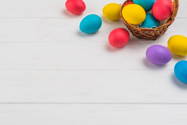 Canasta con huevos de Pascua en mesa de madera