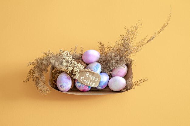 Canasta con huevos de Pascua en una pared aislada de color