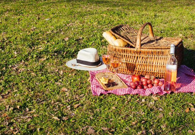 Foto gratuita canasta de picnic con golosinas y vino.