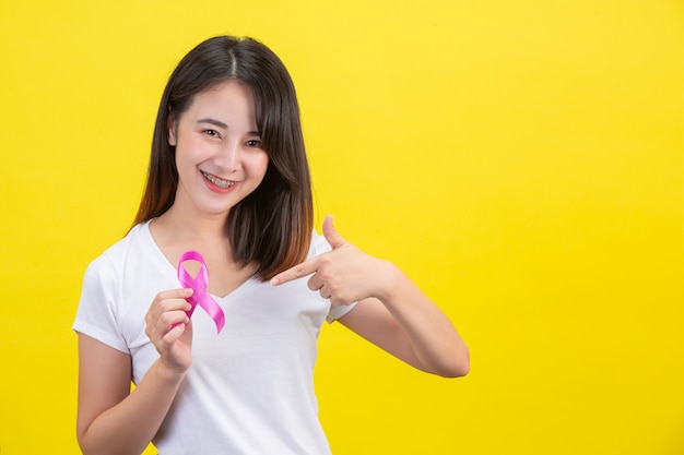 Cáncer de mama, una mujer con una camiseta blanca con una cinta de raso rosa en el pecho, un símbolo para la concientización del cáncer