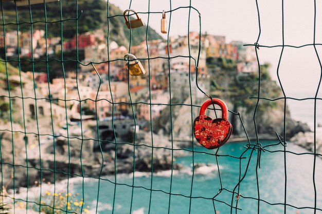 Candado en forma de corazón en la rejilla, Manarola en el fondo: el concepto de romance y amor