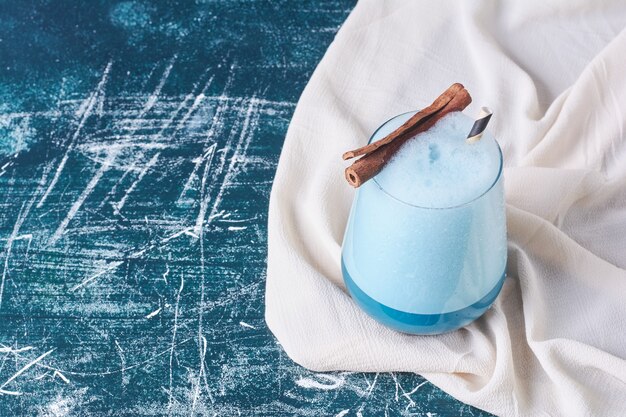 Canela con una taza de bebida en azul.