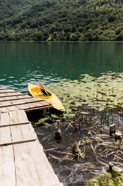 Canoa flotando cerca del muelle de madera en el lago