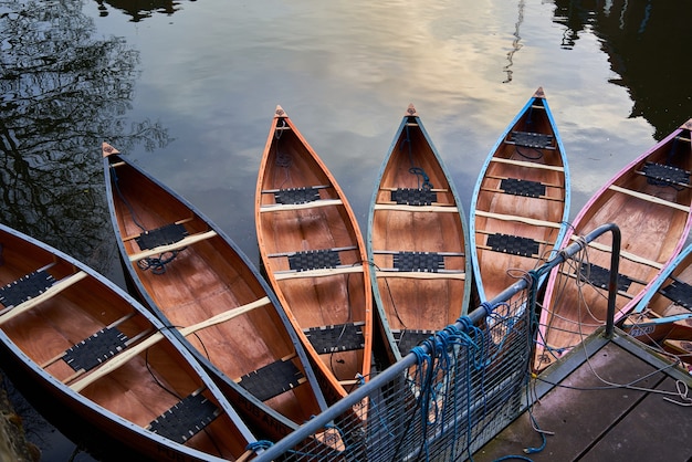 Foto gratuita canoas en el río cerca de un embarcadero en un parque bajo la luz del sol