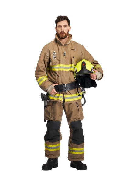Cansado bombero barbudo en uniforme sosteniendo casco protector vista frontal del rescatador masculino de pelo oscuro