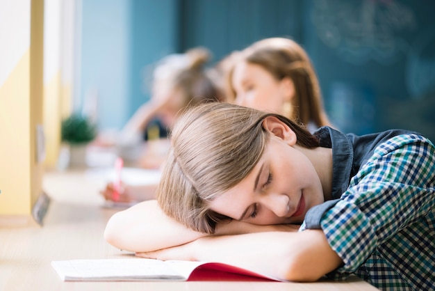 Cansado estudiante durmiendo en la mesa