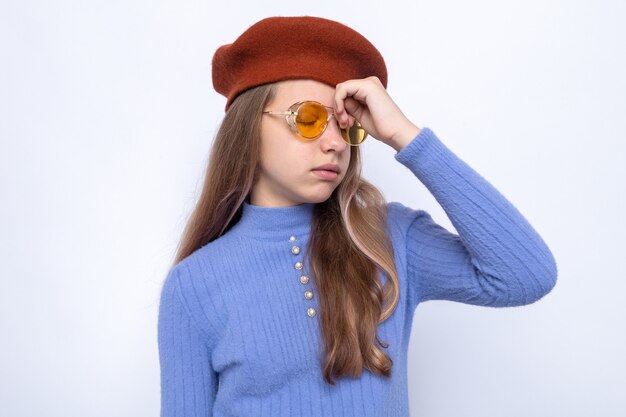 Cansado de poner la mano en la frente hermosa niña con gafas con sombrero