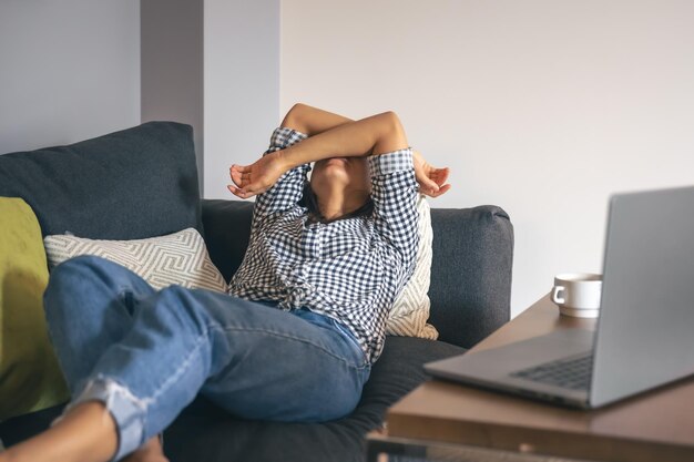 Cansado del trabajo mujer joven frente a una computadora portátil