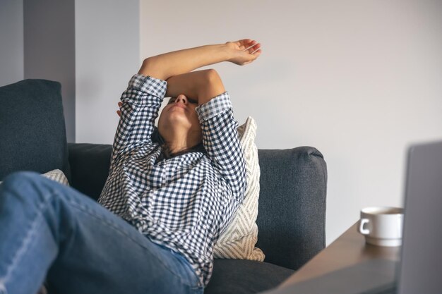 Cansado del trabajo mujer joven frente a una computadora portátil