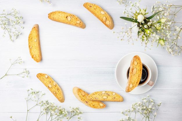 Cantuccini, galletas tradicionales toscanas italianas con almendras, una taza de café a la luz