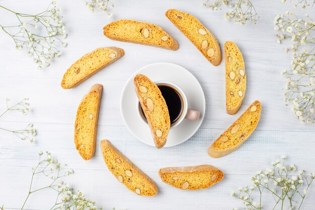 Cantuccini, galletas tradicionales toscanas italianas con almendras, una taza de café a la luz