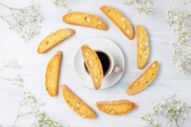Cantuccini, galletas tradicionales toscanas italianas con almendras, una taza de café a la luz