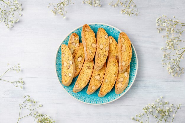 Cantuccini, galletas tradicionales toscanas italianas con almendras, una taza de café a la luz