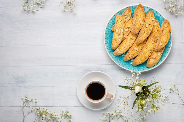 Cantuccini, galletas tradicionales toscanas italianas con almendras, una taza de café a la luz