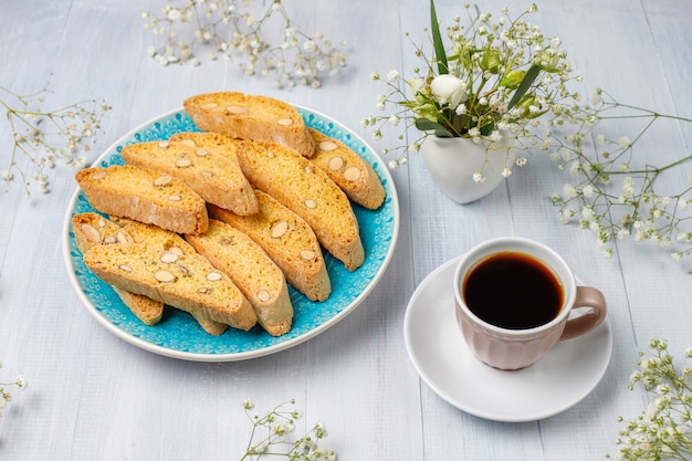 Cantuccini, galletas tradicionales toscanas italianas con almendras, una taza de café a la luz