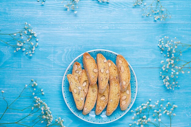 Cantuccini, galletas tradicionales toscanas italianas con almendras, una taza de café a la luz