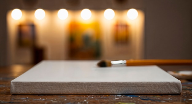 Canvas and paint brush on a wooden table in an art studio