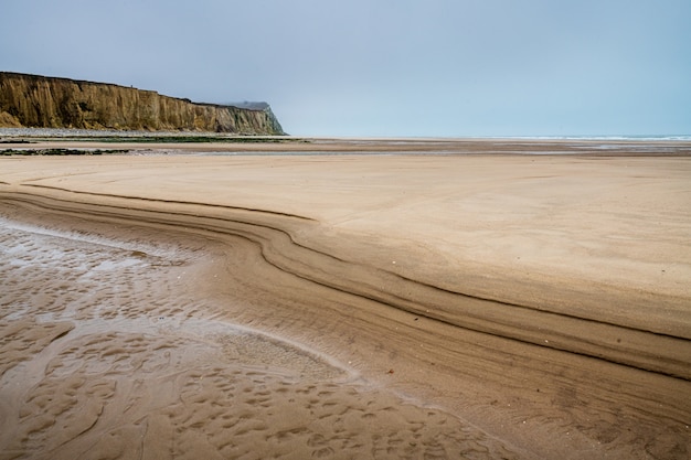 Cap Blanc-Nez rodeado por la playa y el mar bajo el cielo nublado en Francia