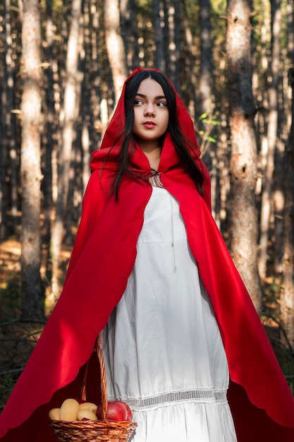 Foto gratuita caperucita roja con canasta de madera con golosinas