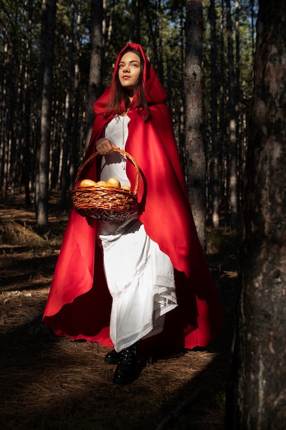 Foto gratuita caperucita roja con canasta de madera con golosinas