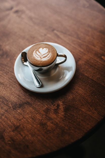 Foto gratuita cappuccino bellamente hecho servido con arte floral en el tiro de espuma desde la vista aérea