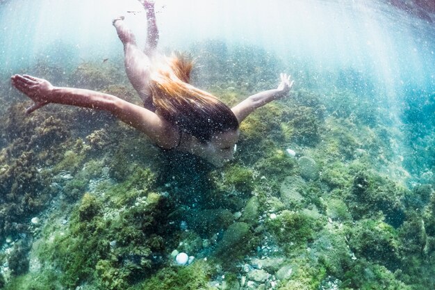 Captura bajo el agua de mujer buceando