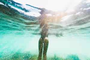 Foto gratuita captura bajo el agua de mujer con tabla de surf