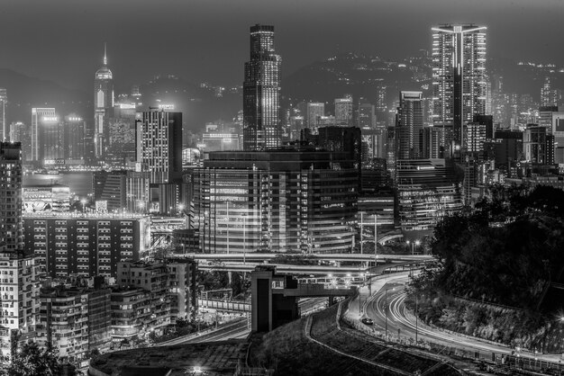 Captura en escala de grises de las hermosas luces y edificios de la ciudad capturados por la noche en Hong Kong