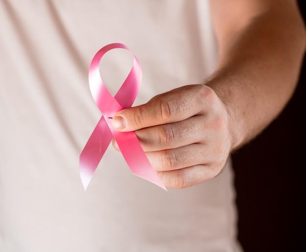 Captura de pantalla de un hombre sosteniendo el símbolo del cáncer de mama