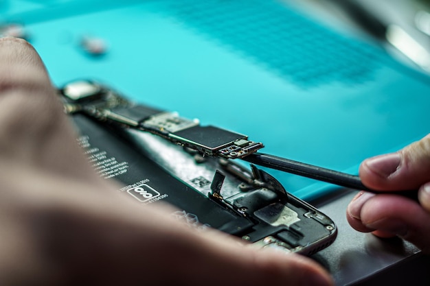 Captura de pantalla de una persona que repara un móvil en un taller de reparación de teléfonos inteligentes