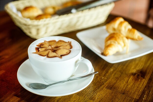 Capuchino y croissants sobre un fondo marrón