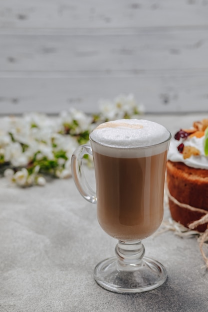 Capuchino en un vaso elegante con un pastel