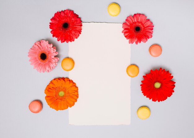Capullos de flores con galletas y papel en la mesa