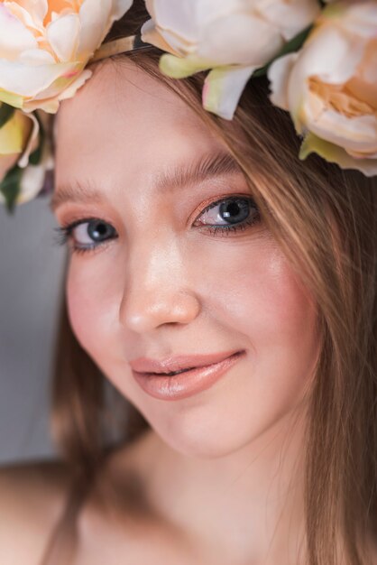 Cara de joven sensual con guirnalda de flores hermosas