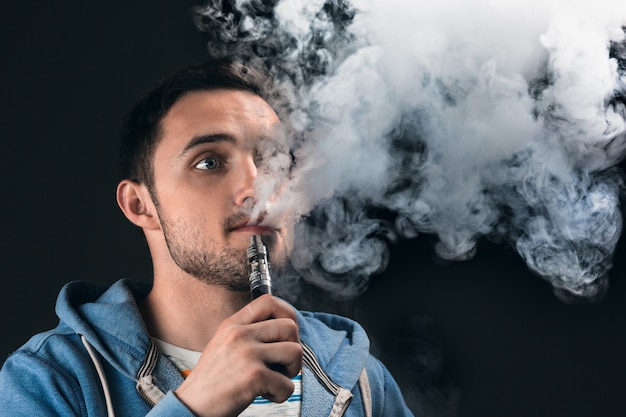 Foto gratuita la cara del joven vaping